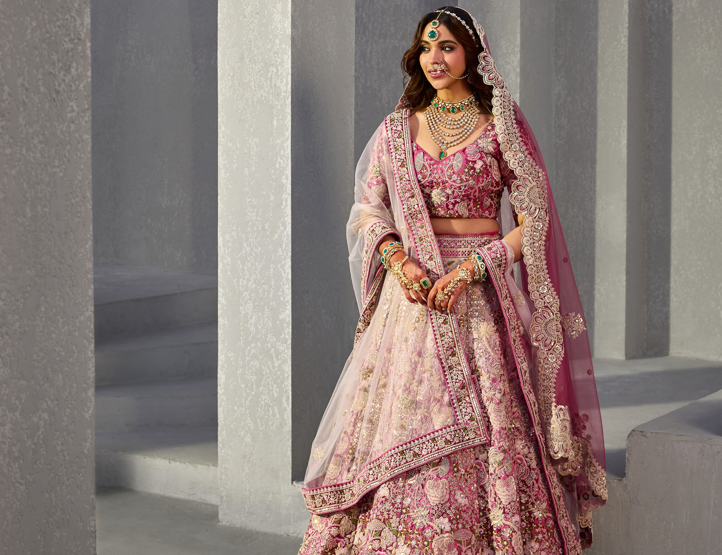 A lady wearing a floral Zari embroidered maroon lehenga